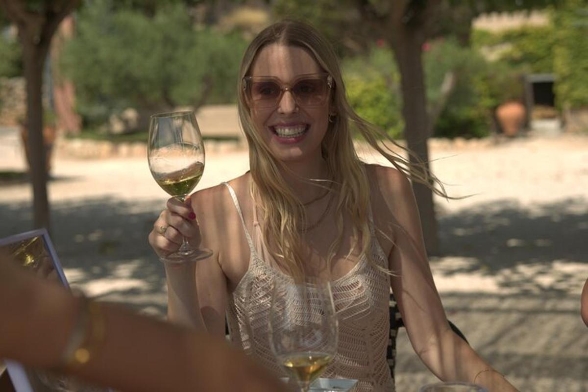 una donna che regge un bicchiere di vino
