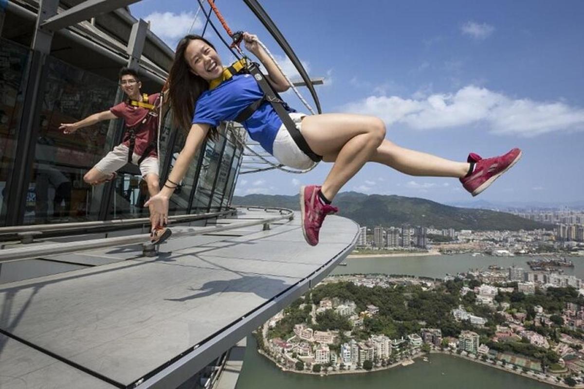 a girl on a zip line on top of a building