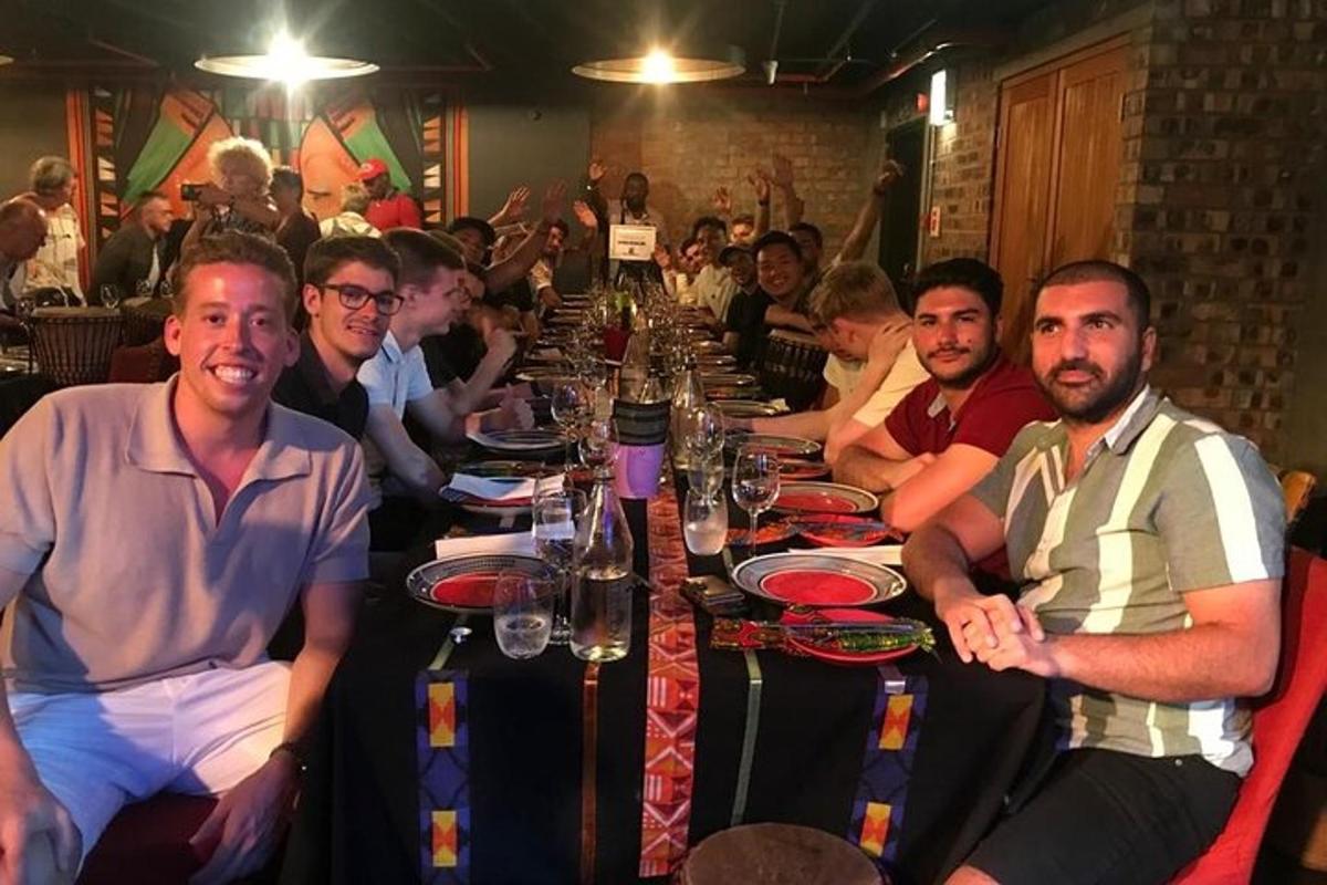 skupina ljudi, ki sedijo za dolgo mizo