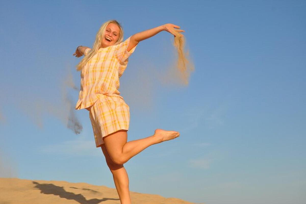 en kvinde i en ternet kjole danser på stranden