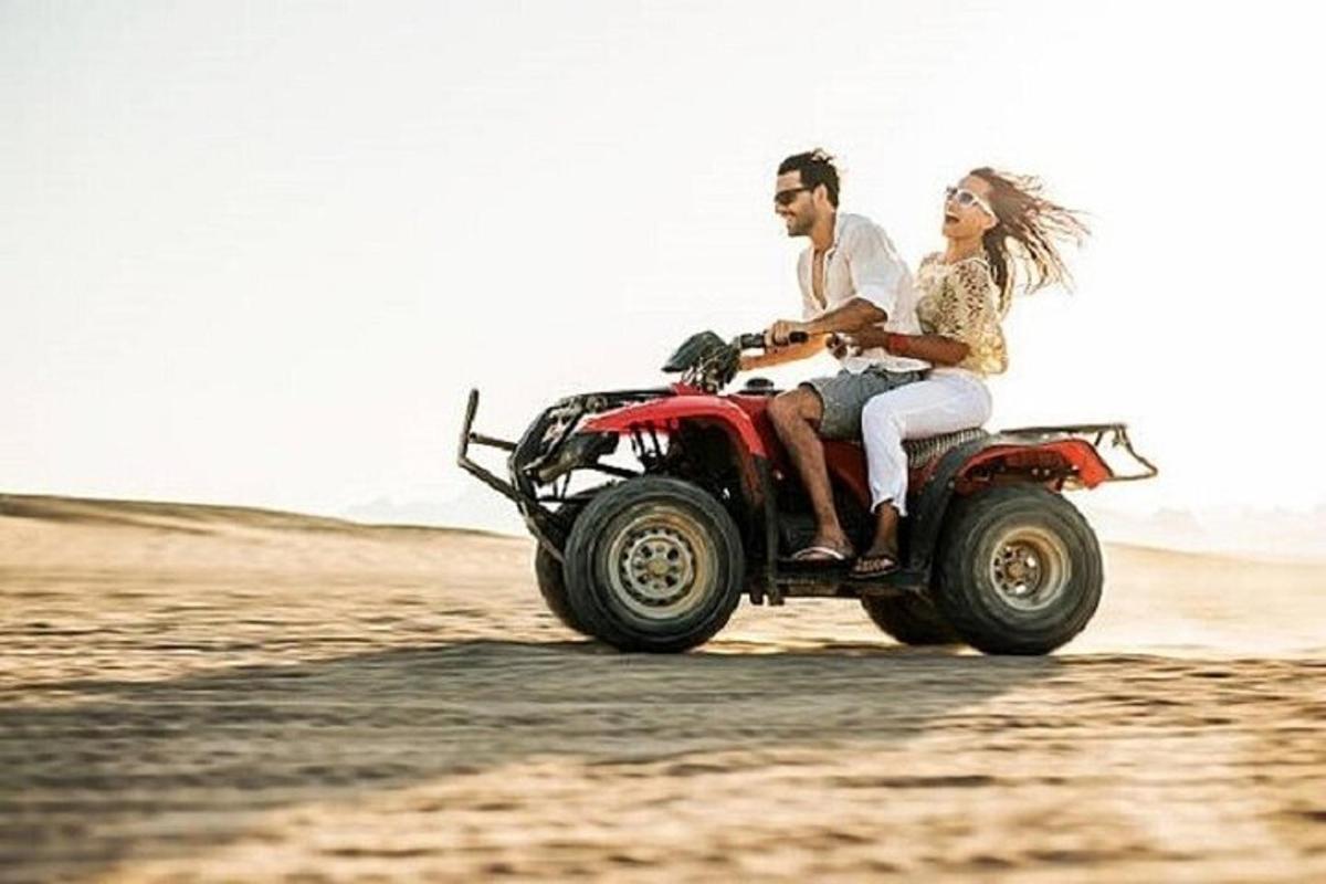 mladenka i mladoženja voze quad u pustinji
