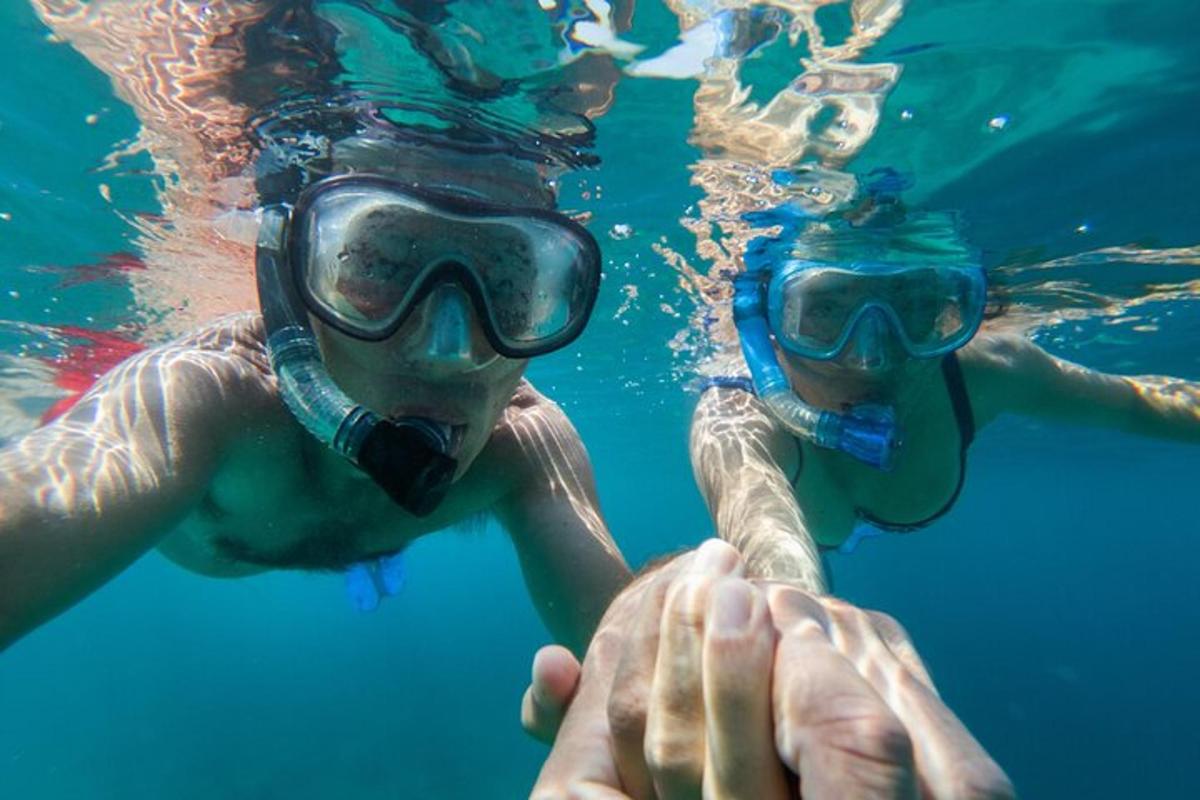 two people are swimming in the water with a diver