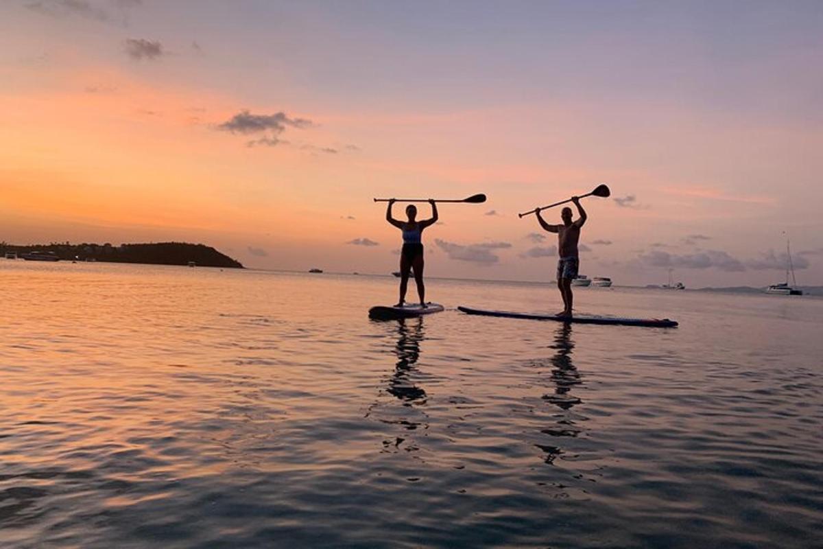 two people standing on a paddle board in the water