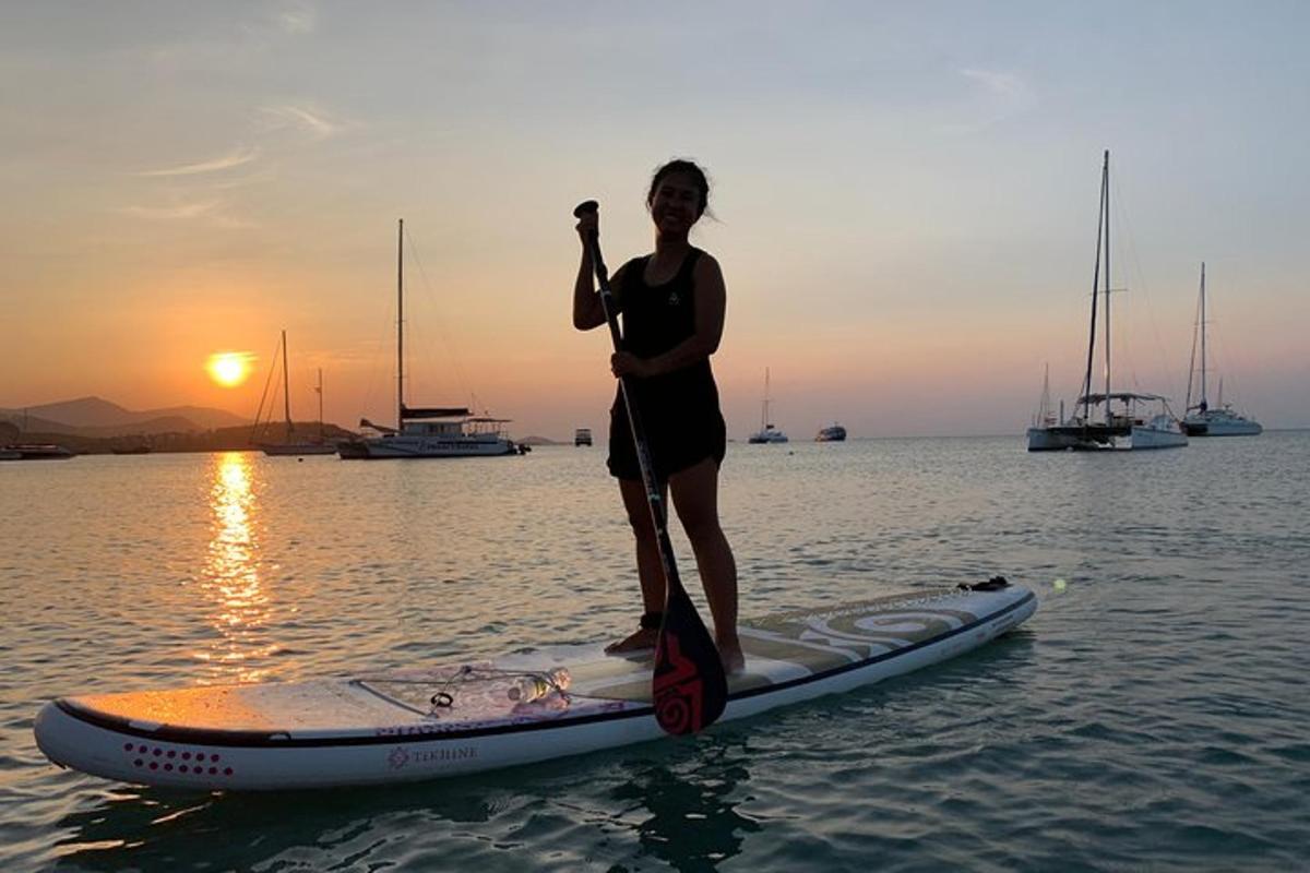 una donna in piedi su una tavola da paddle in acqua
