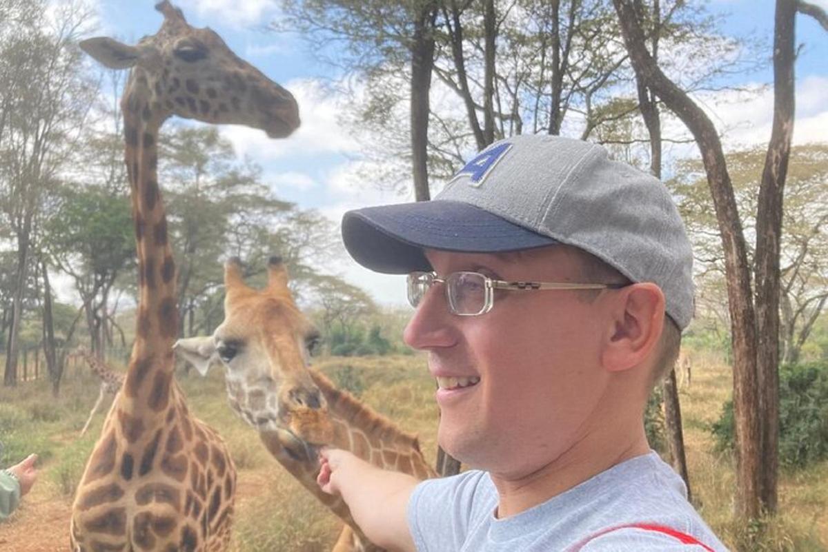Muž stojí před dvěma žirafami