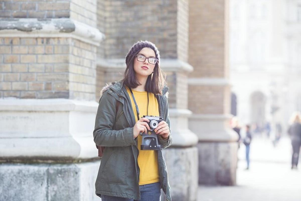 una donna che tiene una macchina fotografica davanti a un edificio