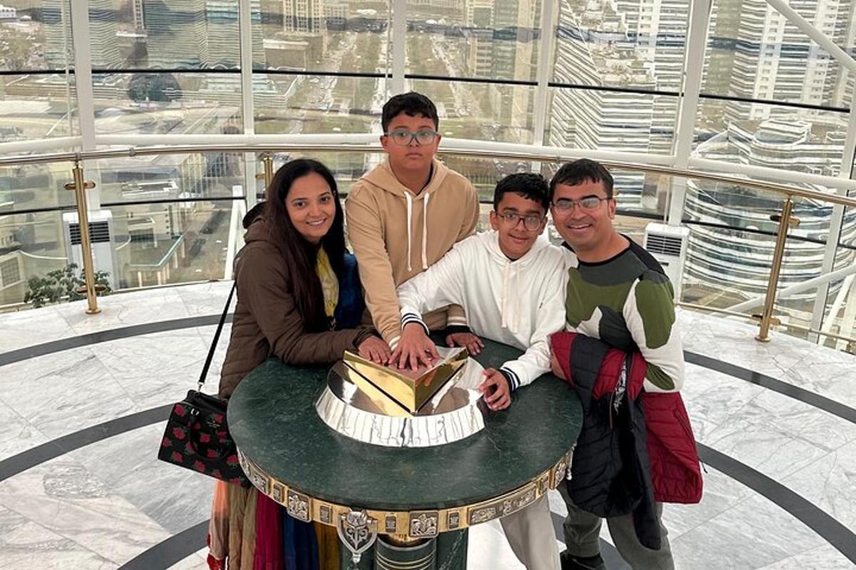 a group of people standing around a table with a cake