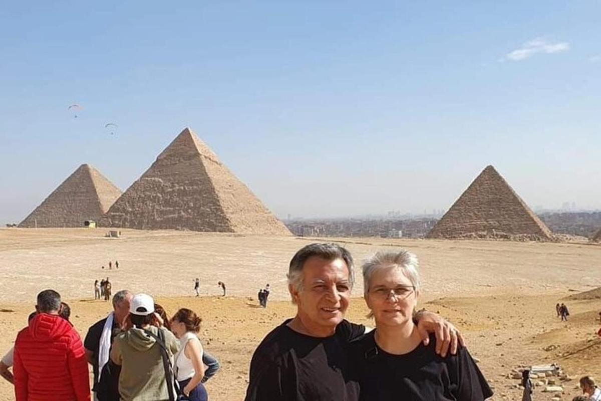 Un hombre y una mujer de pie frente a las pirámides.