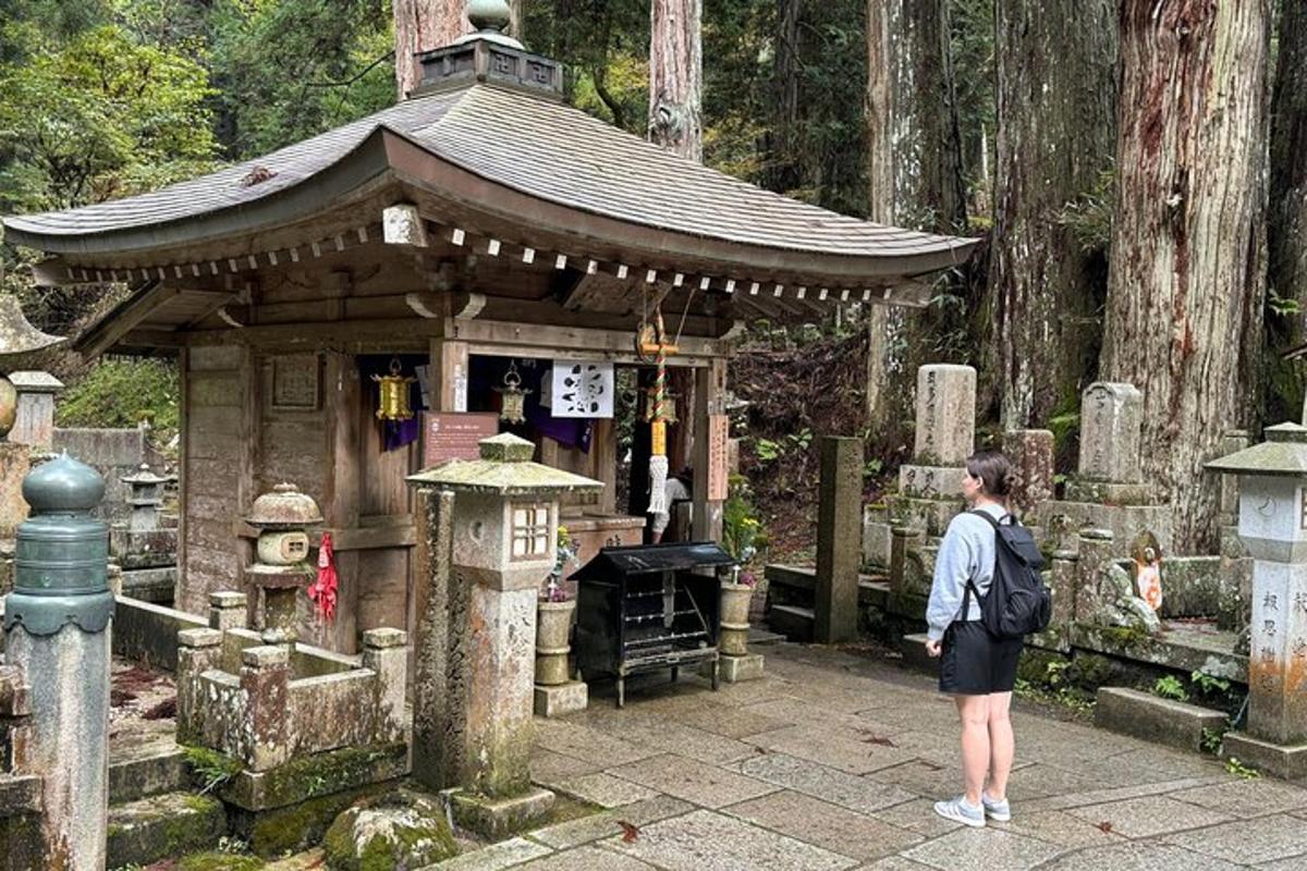 一位女士站在一座小神社前