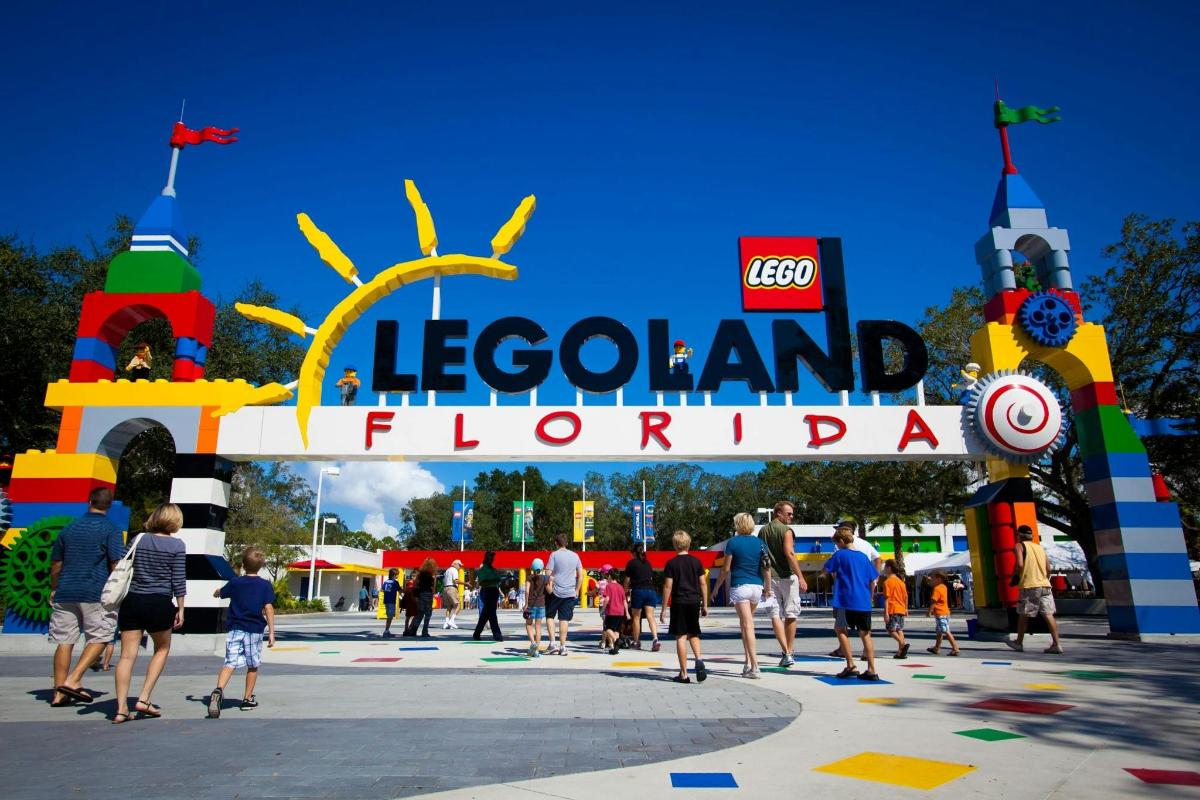 a group of people walking around a theme park