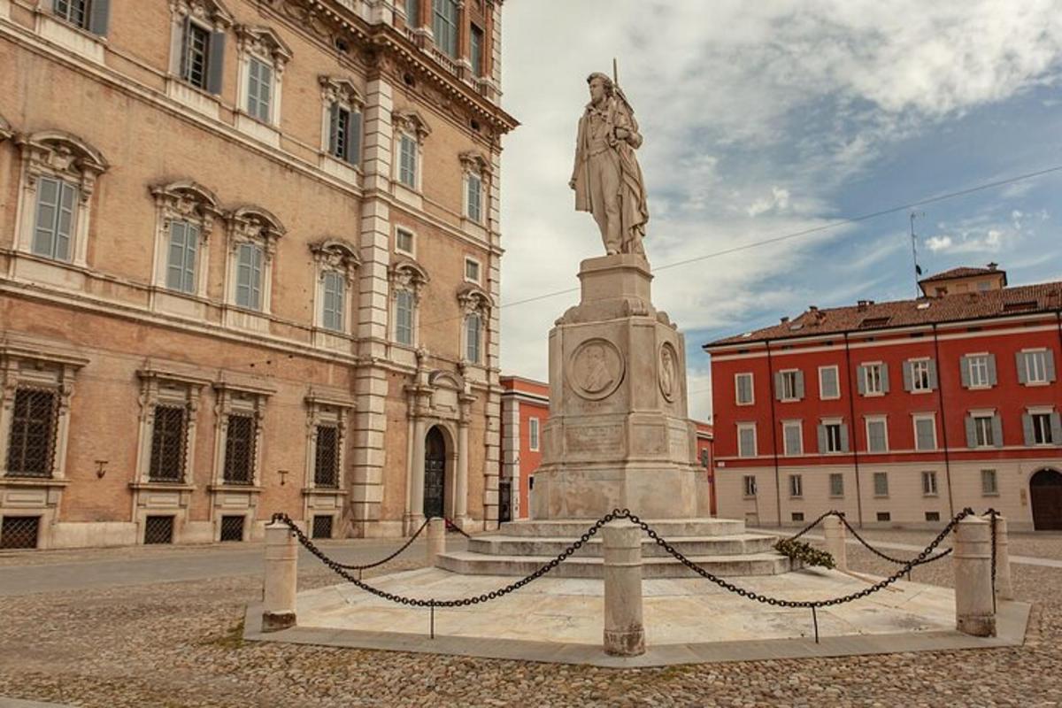 eine Statue mitten in einer Stadt mit einem Gebäude