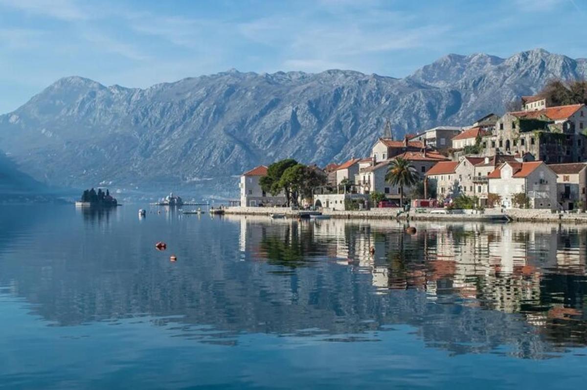 een stad aan het water met bergen op de achtergrond