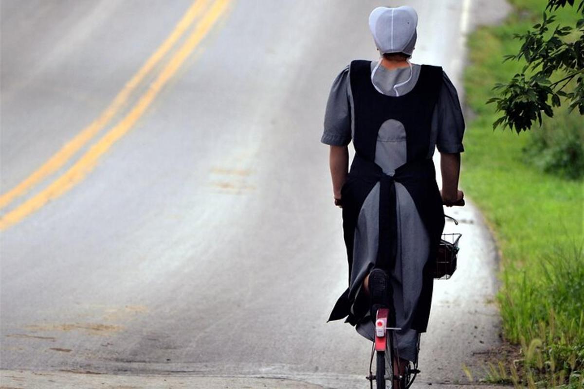 一名女子骑着自行车在路上行驶