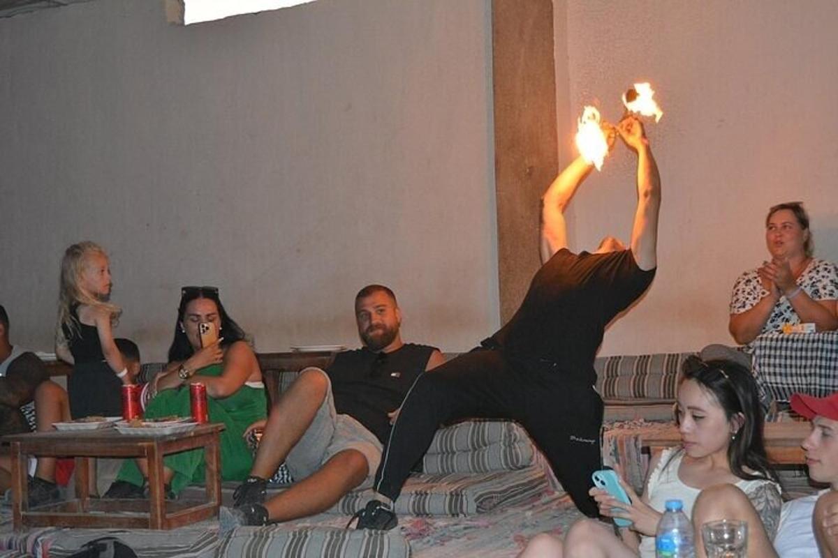 un grup de persones assegudes en un sofà amb un home que sosté torxes