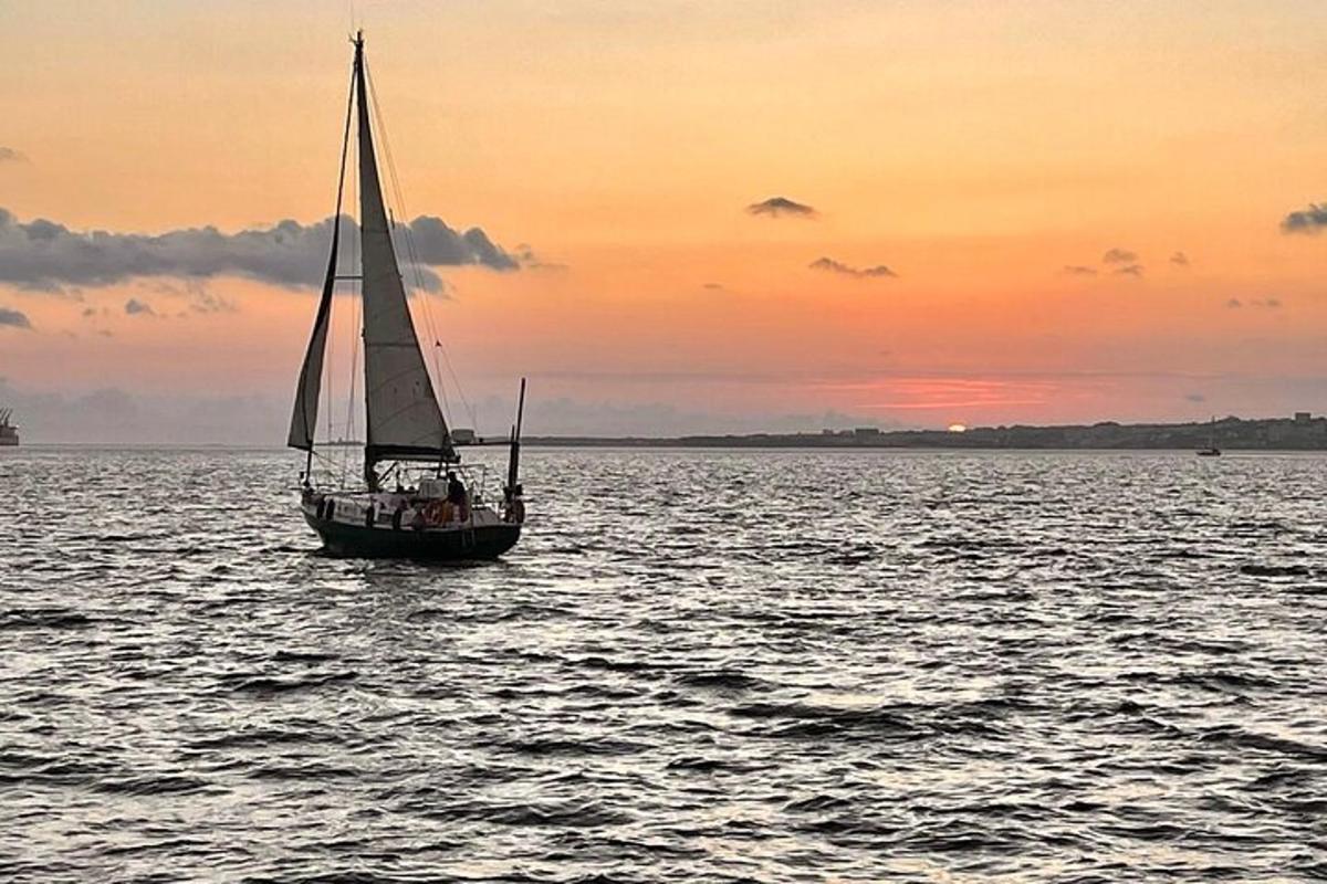una barca a vela in acqua al tramonto