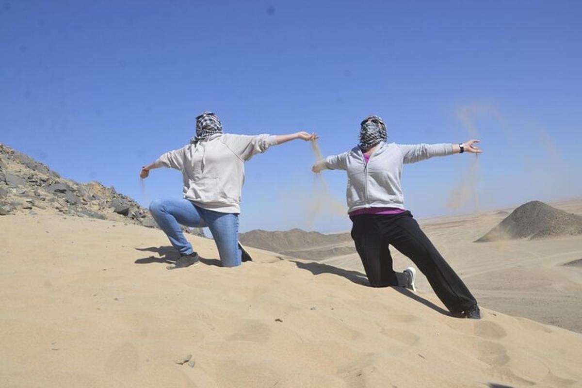 duas pessoas em pé na areia do deserto