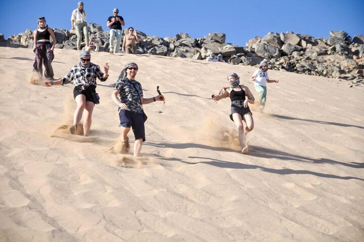 um grupo de pessoas correndo na areia
