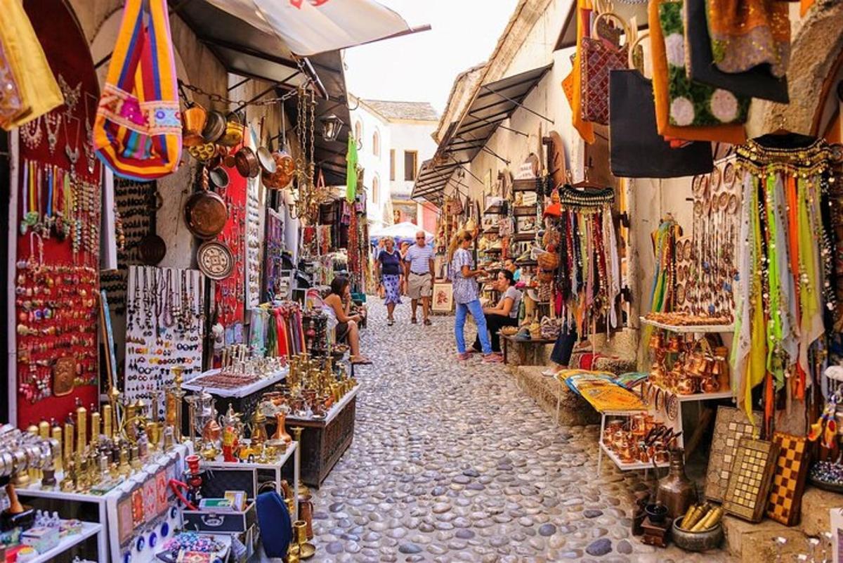 a group of people walking through a market with shops