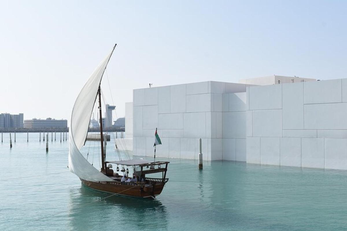 a boat with a sail in the water next to a building