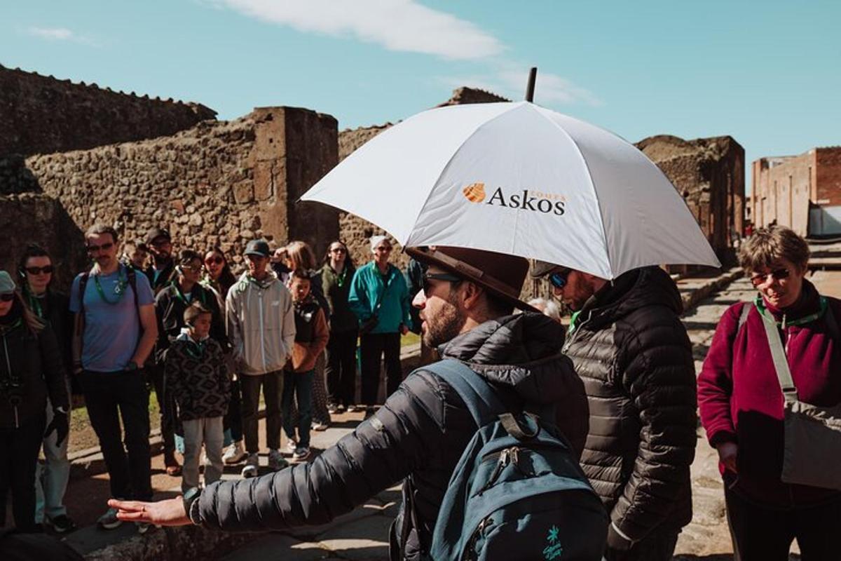 um homem segurando um guarda-chuva na frente de um grupo de pessoas