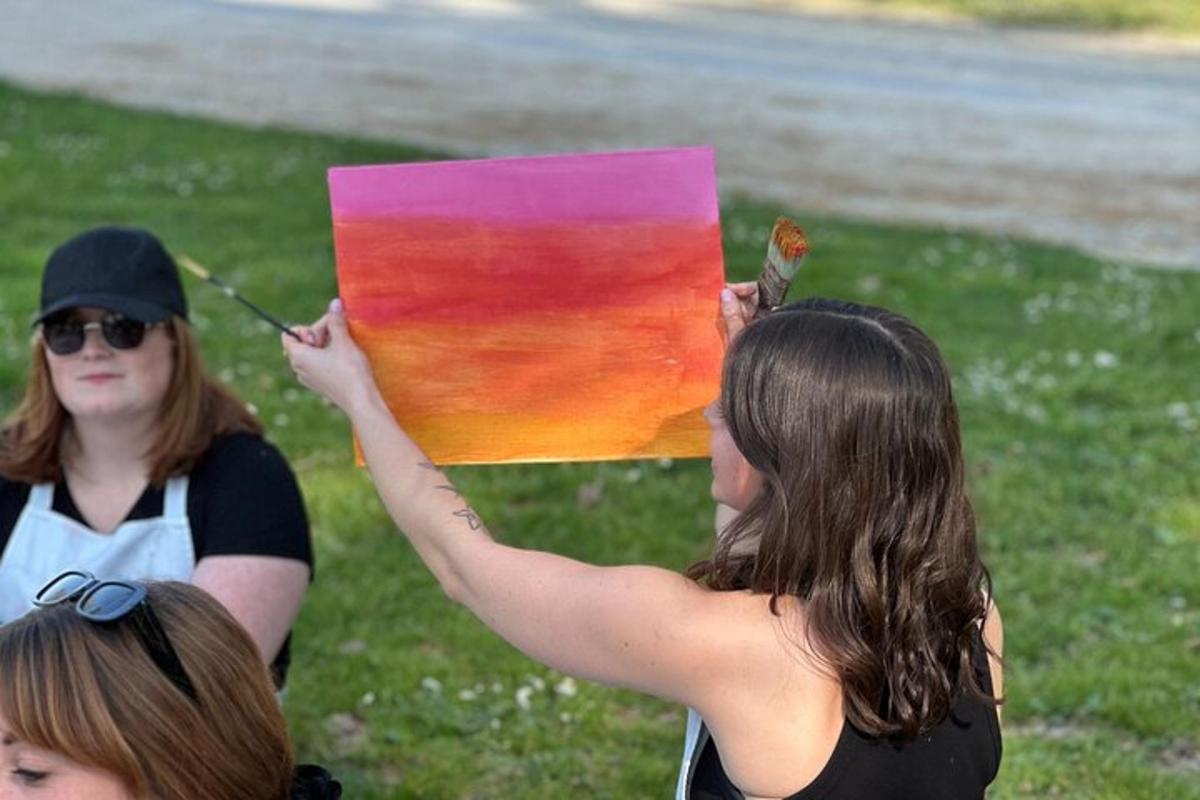 a woman holding up a painting with a butterfly on it