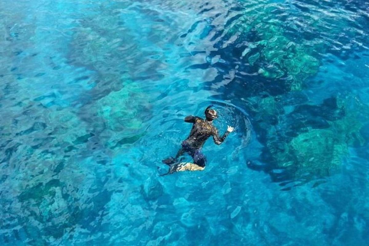 un uomo sta nuotando nell'acqua blu