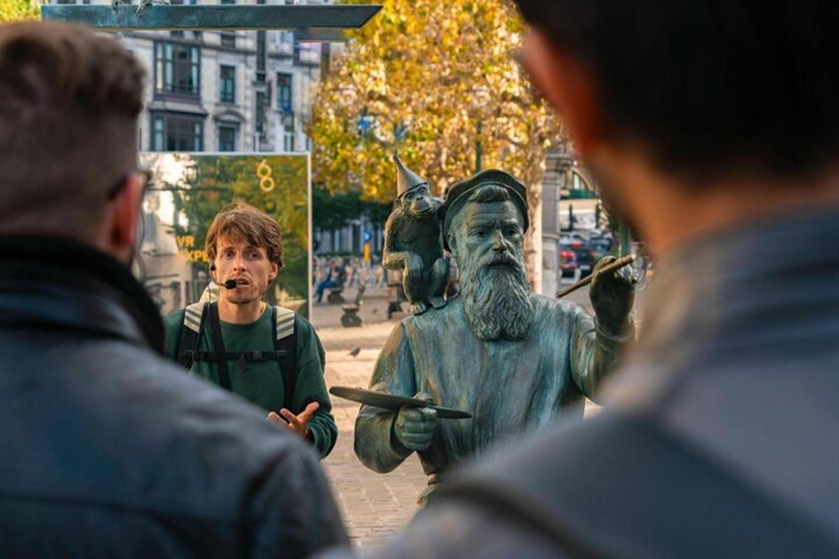 un uomo in piedi accanto alla statua di un uomo
