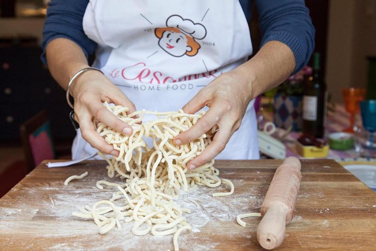 Una persona está preparando fideos en una tabla de cortar.