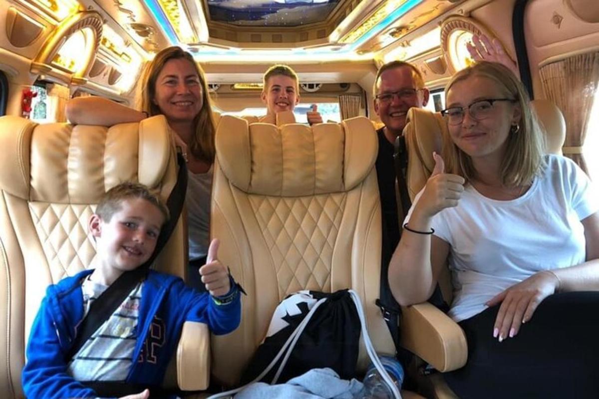 skupina lidí sedících v autobuse a ukazujících palec nahoru
