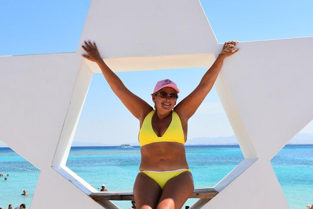 Una mujer en bikini amarillo sentada en una playa