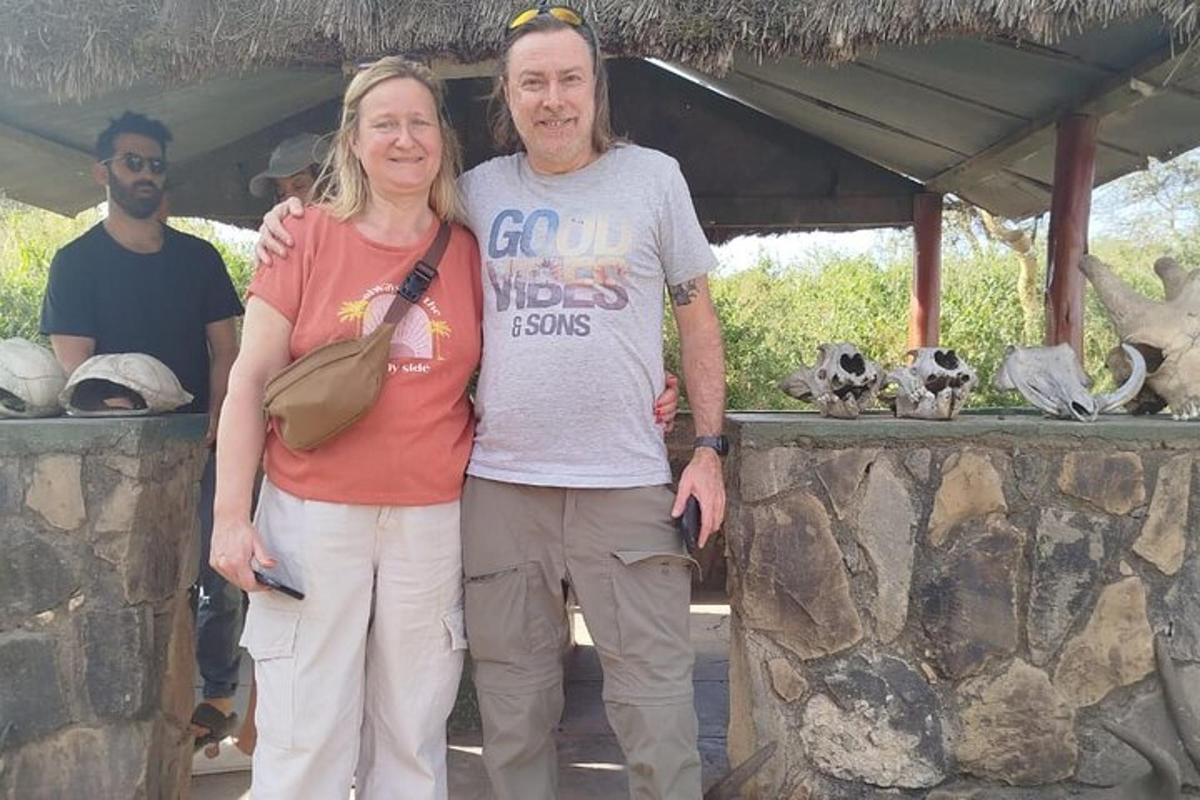 muškarac i žena stoje uz kameni zid