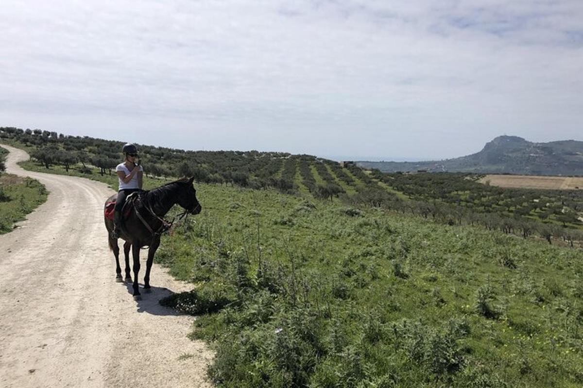 una donna a cavallo su una strada sterrata