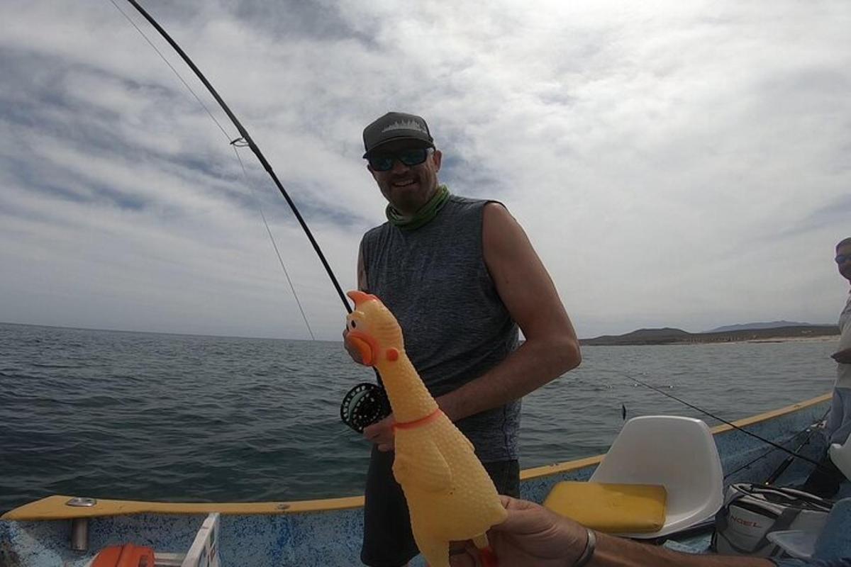 a man holding a fish on a fishing boat