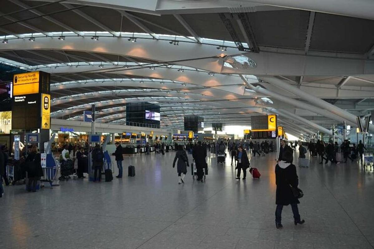 un gruppo di persone che camminano intorno al terminal di un aeroporto
