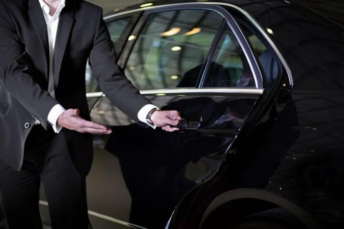 un uomo in giacca e cravatta in piedi accanto a un'auto