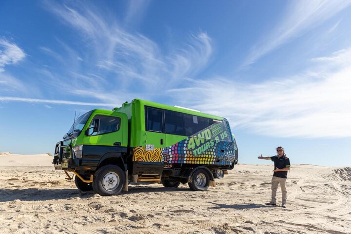 a man standing next to a green truck in the desert