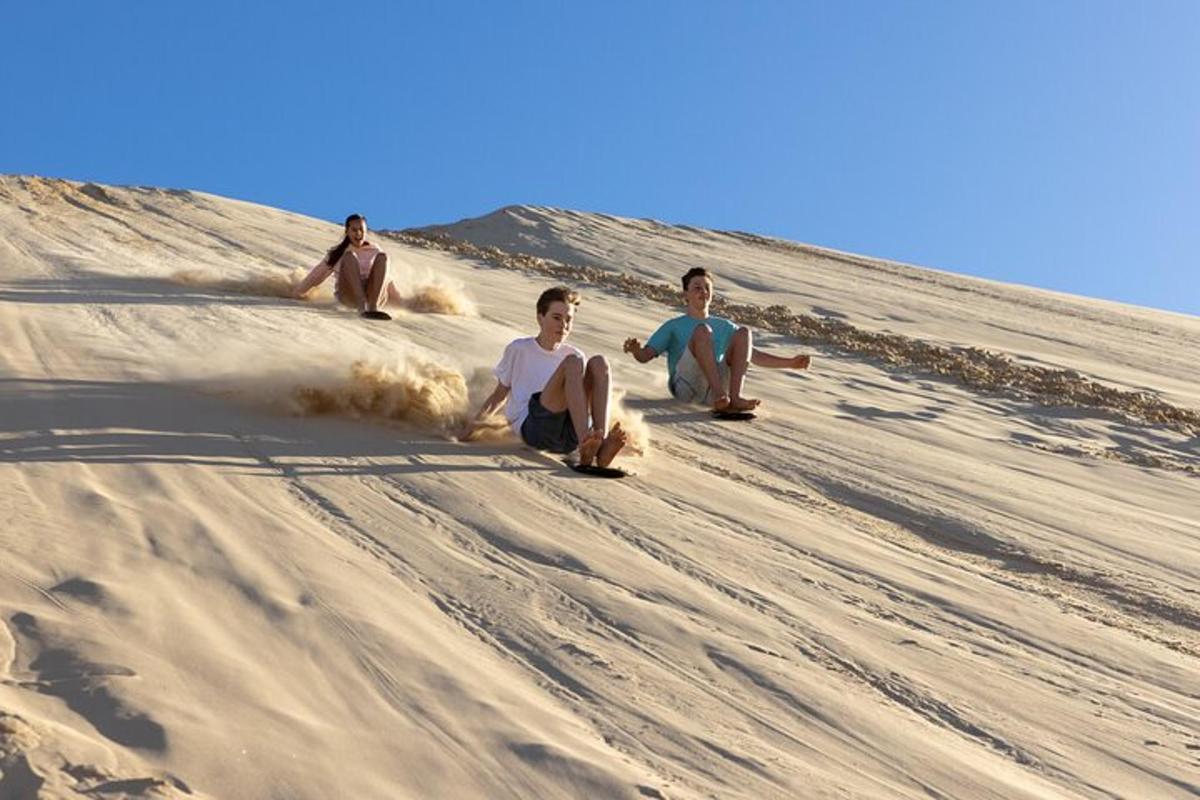 three men sitting on the sand in the desert