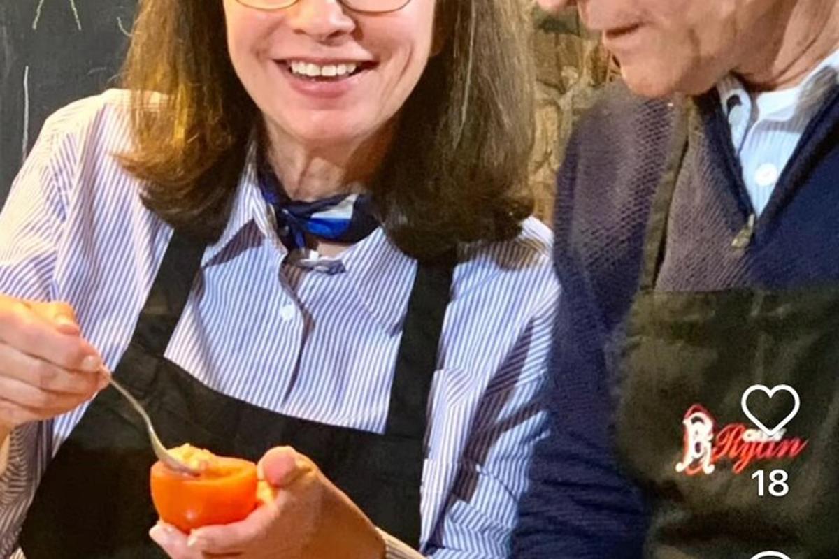 a woman is eating a tomato with a spoon