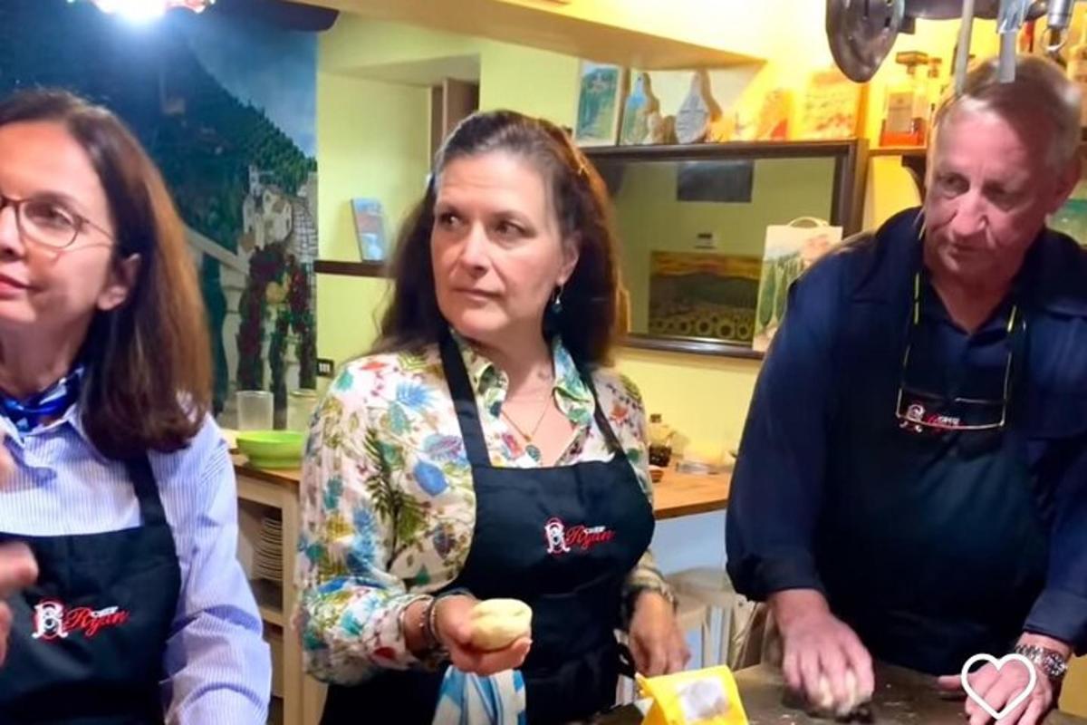 a man and two women standing in a kitchen