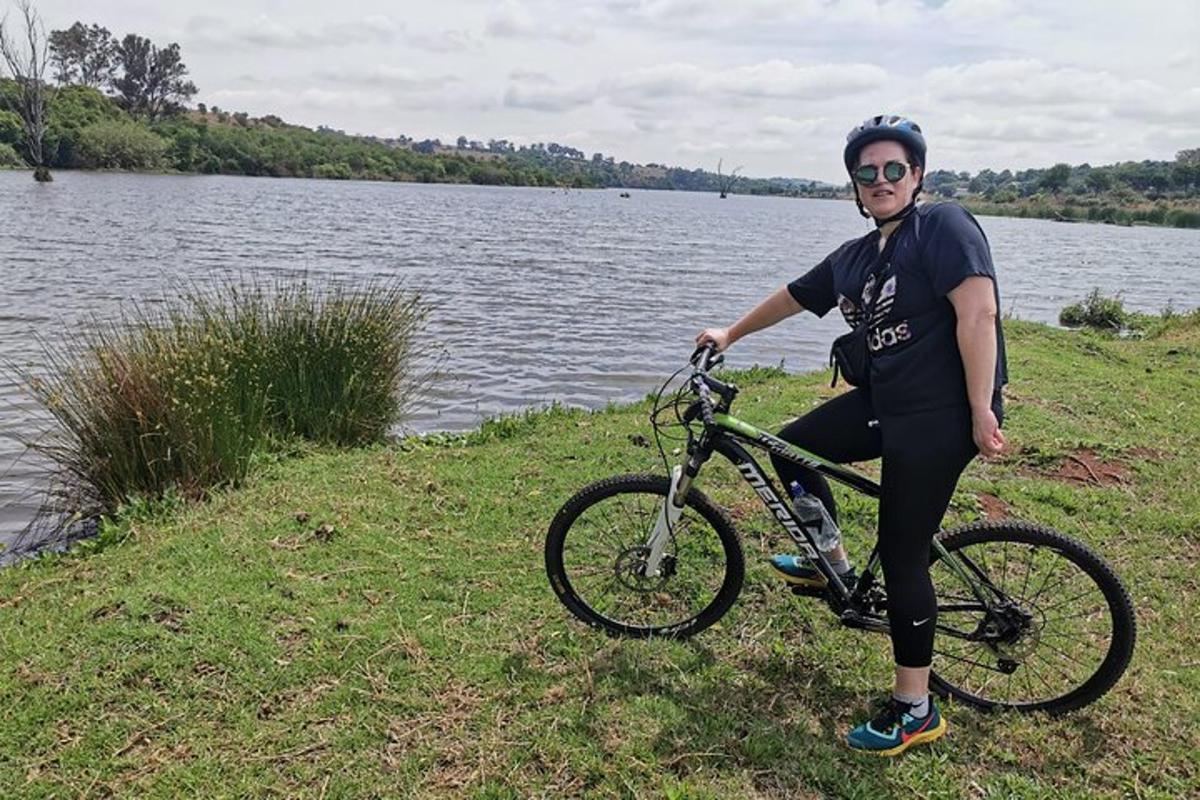 um homem sentado em uma bicicleta perto de um lago