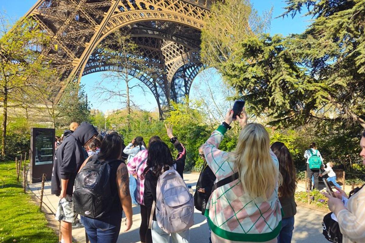a group of people standing in front of the eiffel tower