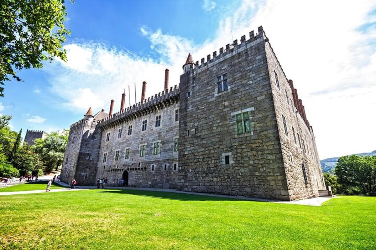 a large castle with a grass field in front of it
