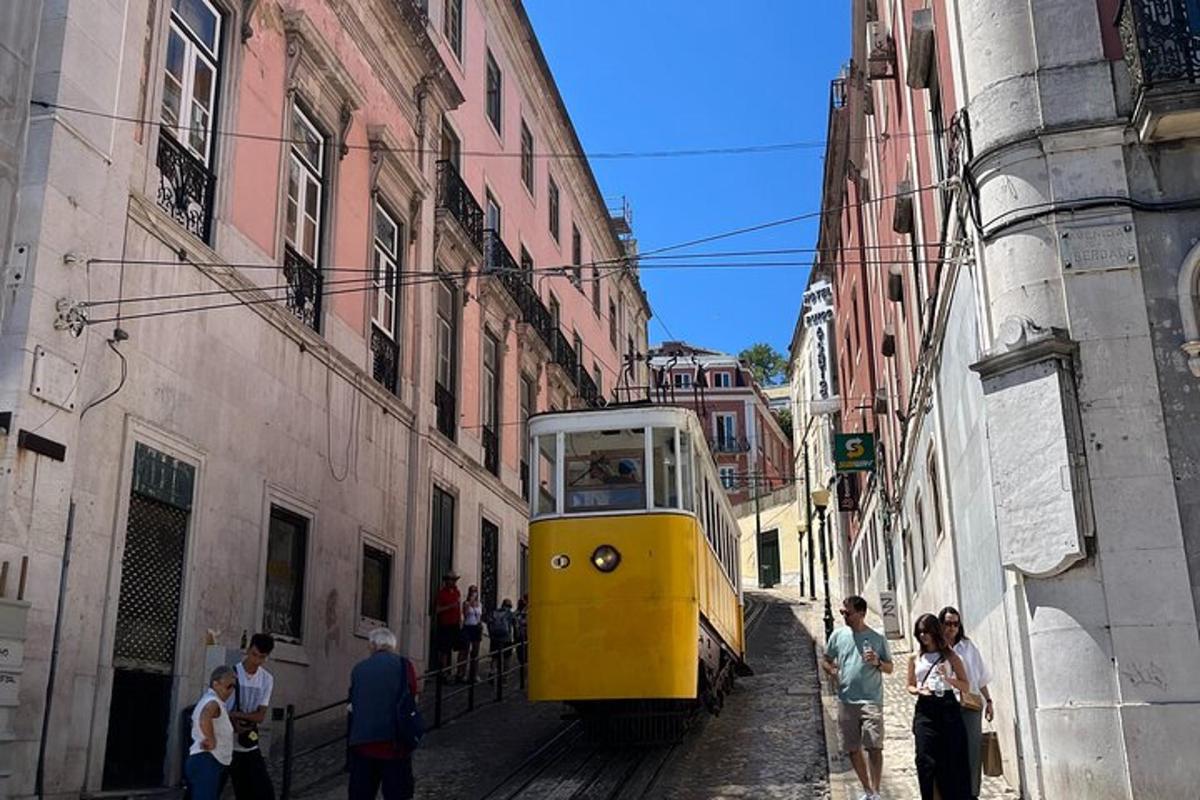 eine gelbe Straßenbahn auf einer engen Straße mit herumstehenden Menschen