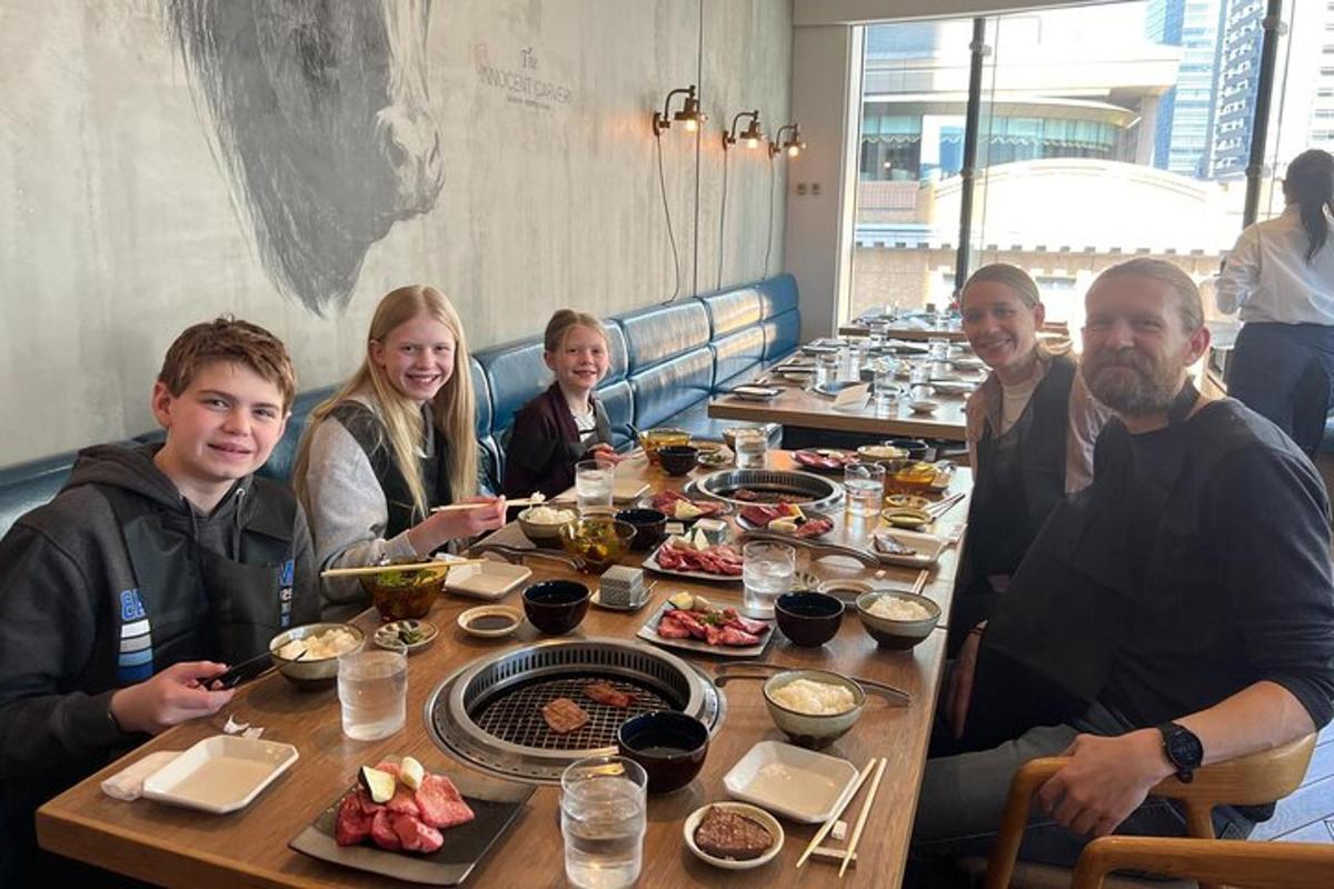 a group of people sitting at a table with food