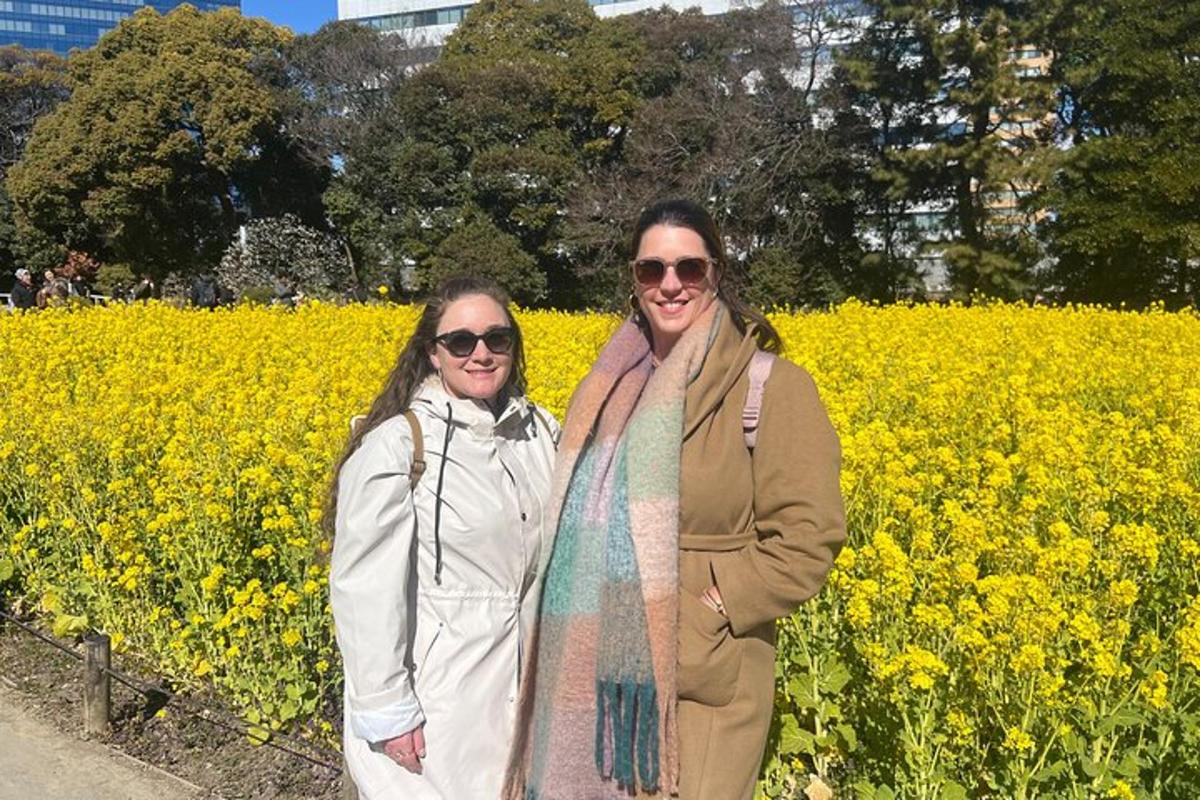 two women standing in front of a rapeseed field