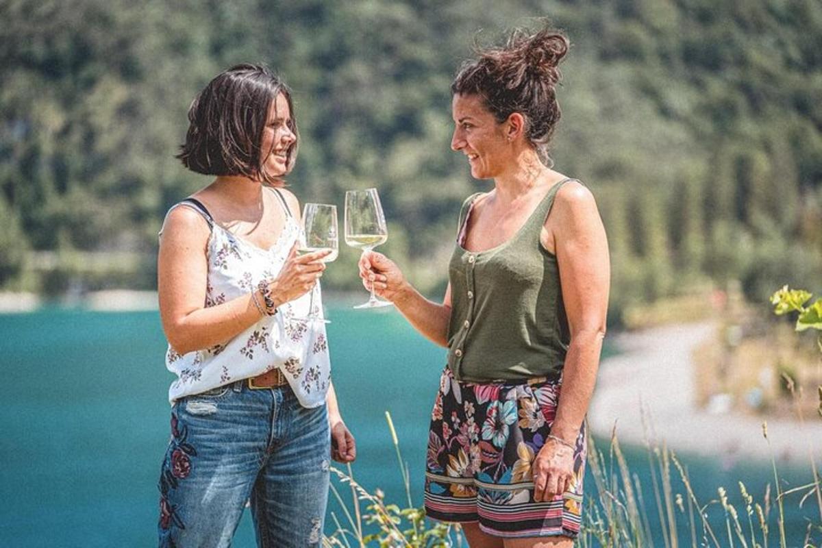 dvije žene stoje jedna pored druge držeći čaše vina