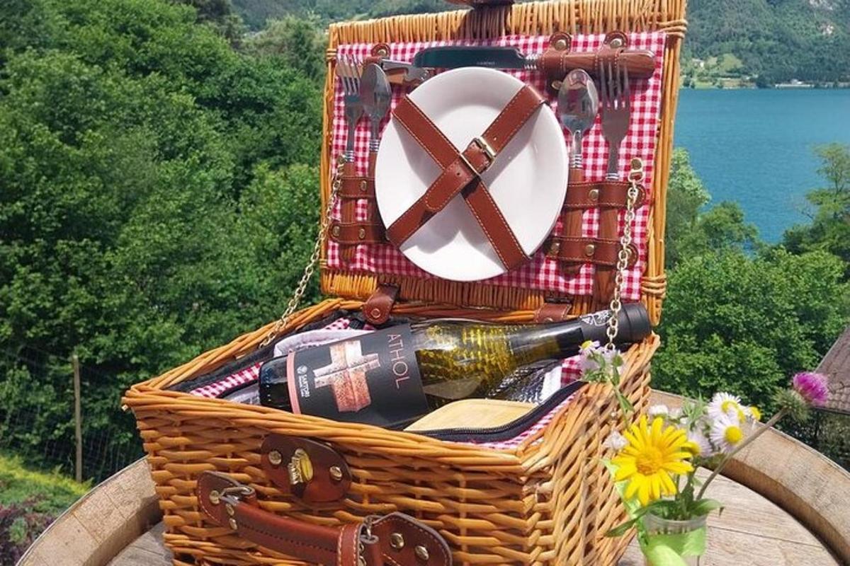 một giỏ đựng đồ ăn dã ngoại với một chai rượu và một chiếc khăn ăn
