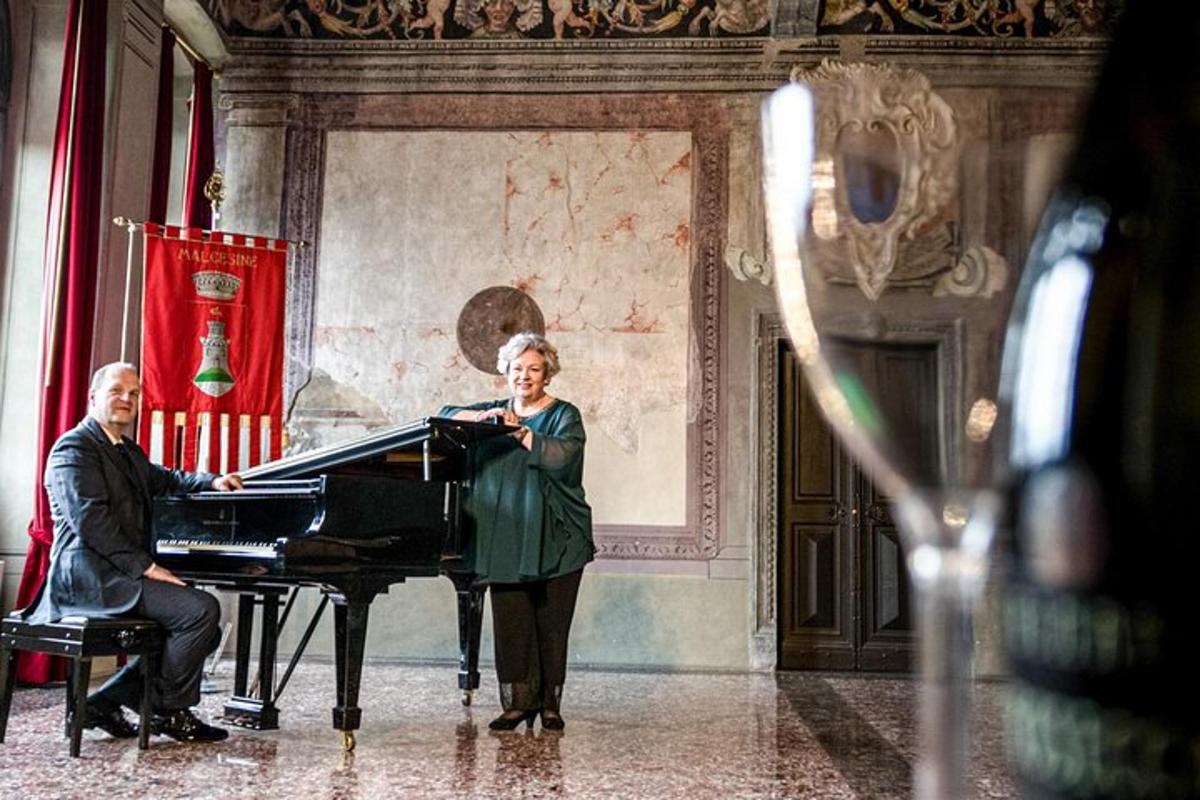 um homem e uma mulher em pé ao lado de um piano