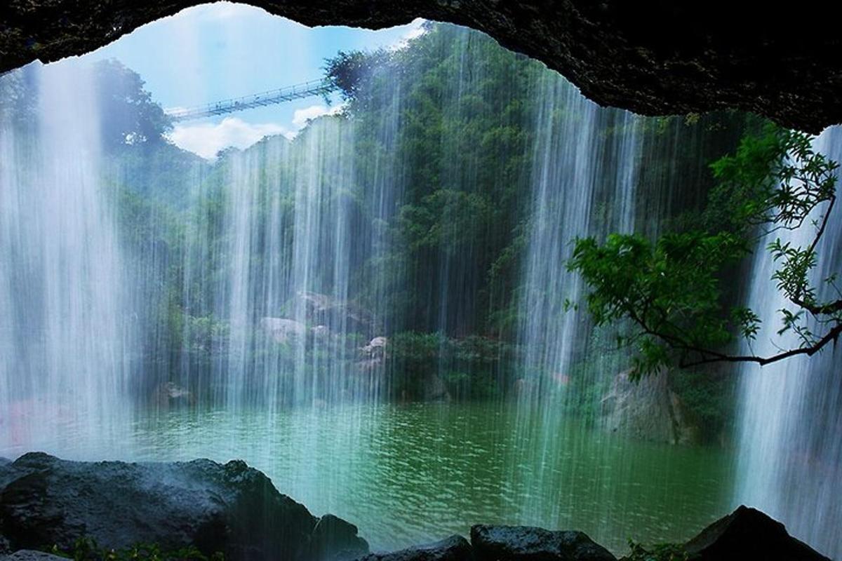 a waterfall over a pool of water in front of a lake