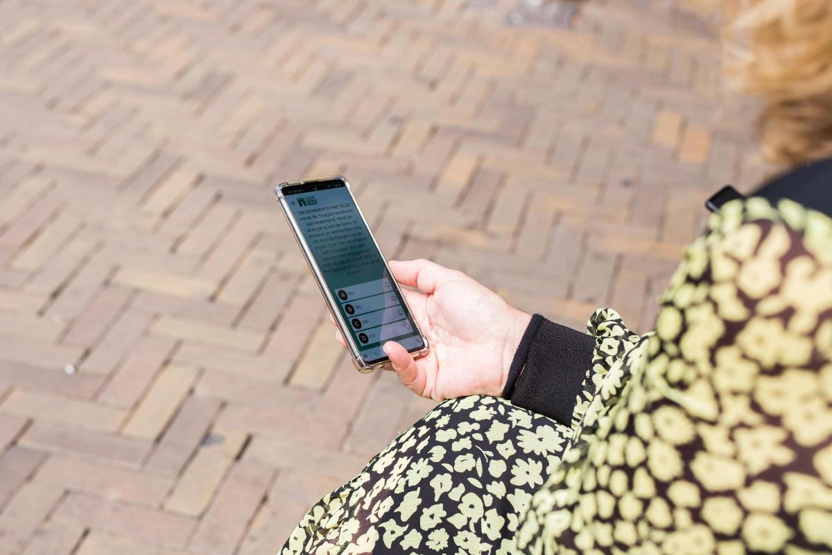 žena držící v ruce mobilní telefon